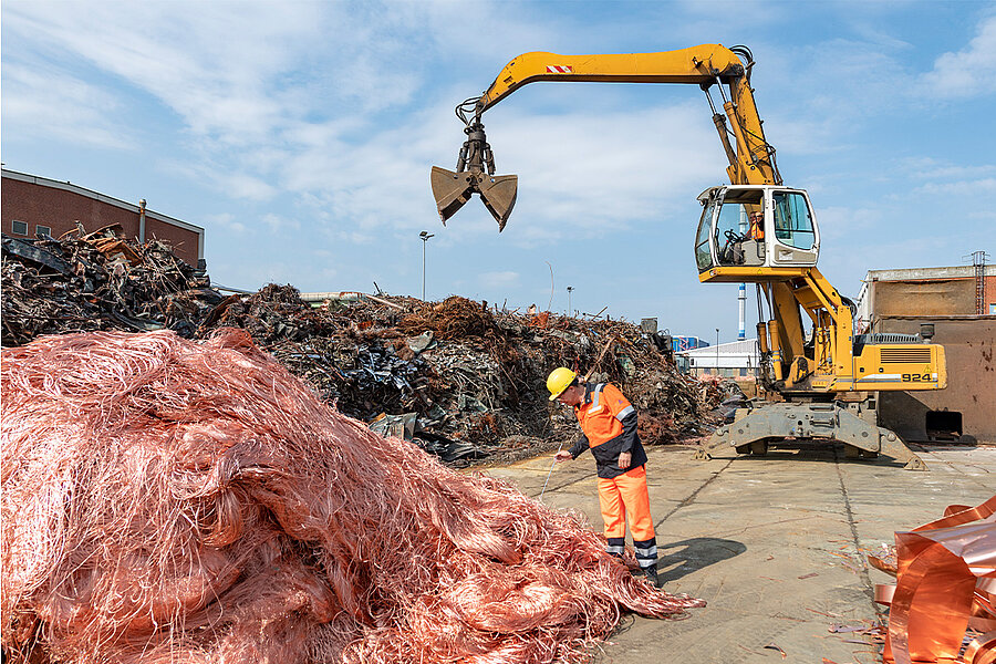 Foto: Aurubis: Bagger neben einem Kupferhaufen